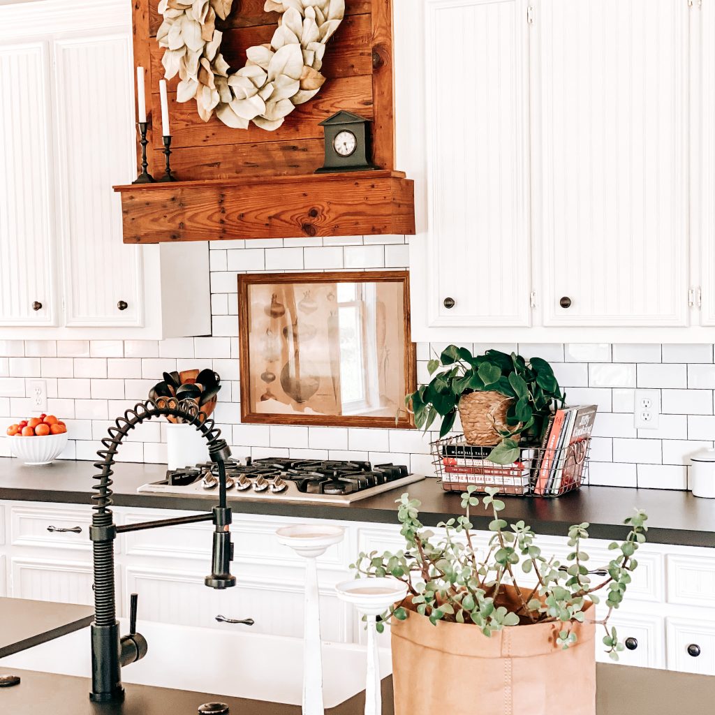 The Yellow Rose Farmhouse Kitchen Decor with view of farmhouse sink, barn wood range hood, subway tile backsplash, vintage vegetable print and rustic farmhouse decor