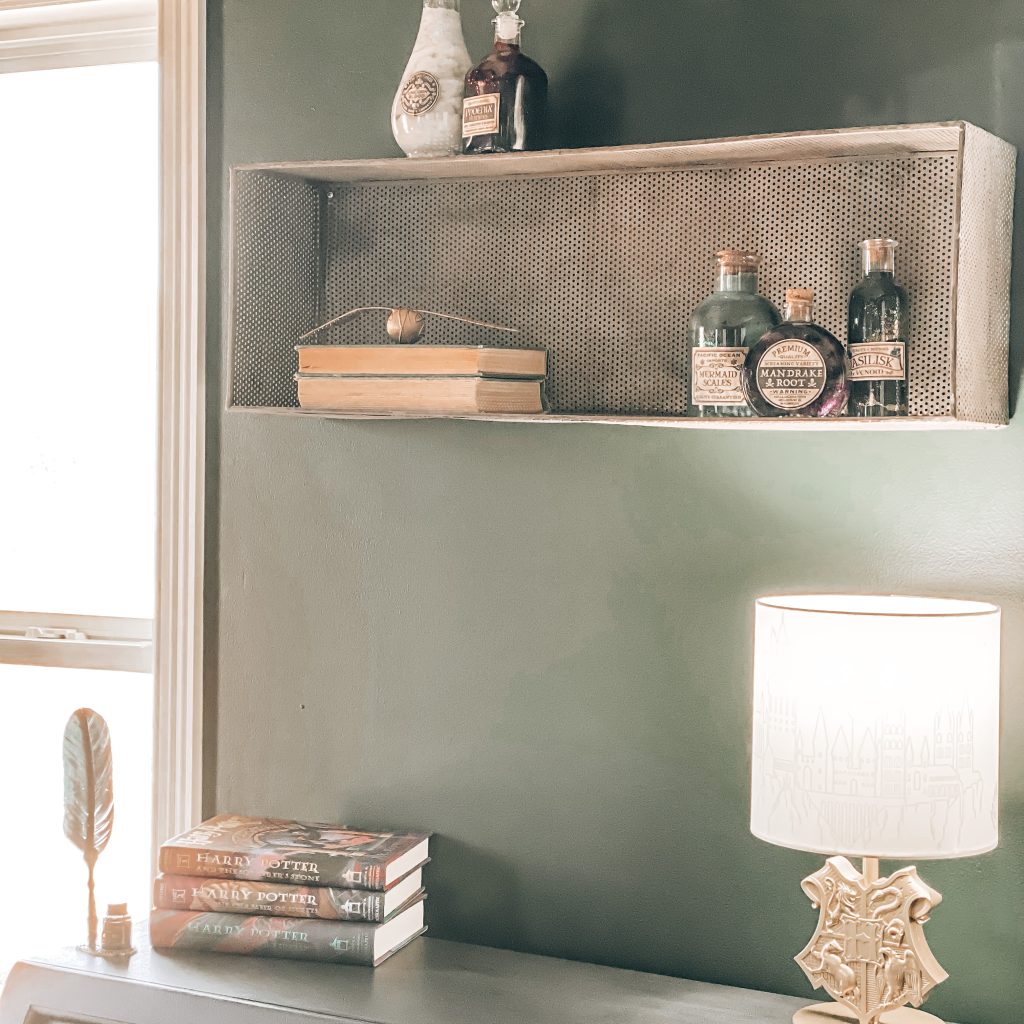 Side view of shelf that is decorated with vintage books, the golden snitch from quidditch and DIY Magical Harry Potter Potions with labels | The Yellow Rose Farmhouse | www.theyellowrosefarmhouse.com