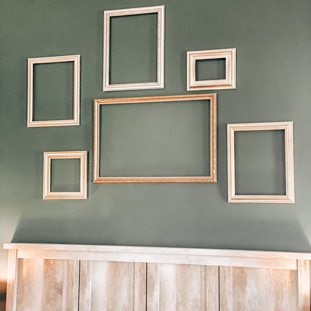 Close up of one of the walls that has different sized gold frames hanging on it to mimic the Hogwarts castle walls | The Yellow Rose Farmhouse | www.theyellowrosefarmhouse.com