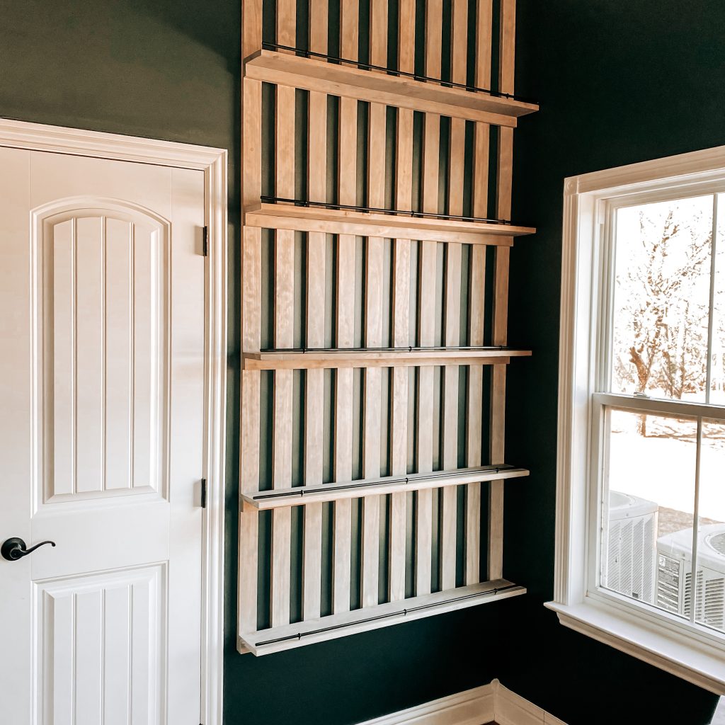 DIY Wood Slat Accent Wall with shelves stained with weathered oak stain and painted black railing on dark green walls in Harry Potter inspired boy's bedroom | The Yellow Rose Farmhouse | www.theyellowrosefarmhouse.com