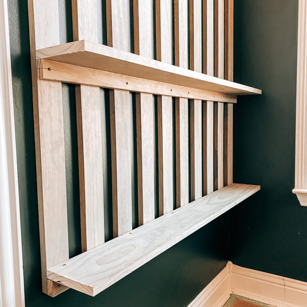 Close up of the DIY Wood Slat Accent Wall with the bottom two shelves attached on a dark green wall in a Harry Potter Inspired boy's bedroom | The Yellow Rose Farmhouse | www.theyellowrosefarmhouse.com
