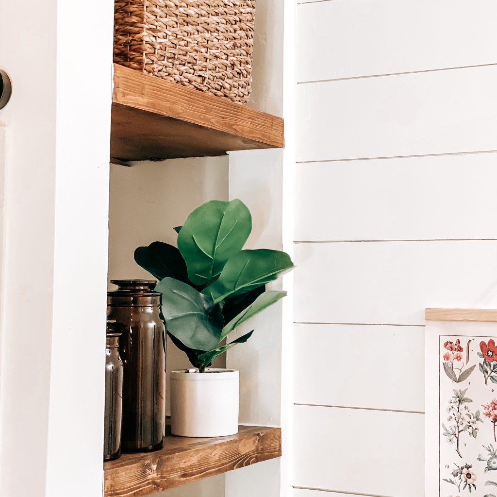 DIY Floating Shelves in modern farmhouse bathroom decorated with amber canisters, a fiddle leaf plant and hyacinth baskets | The Yellow Rose Farmhouse | www.theyellowrosefarmhouse.com
