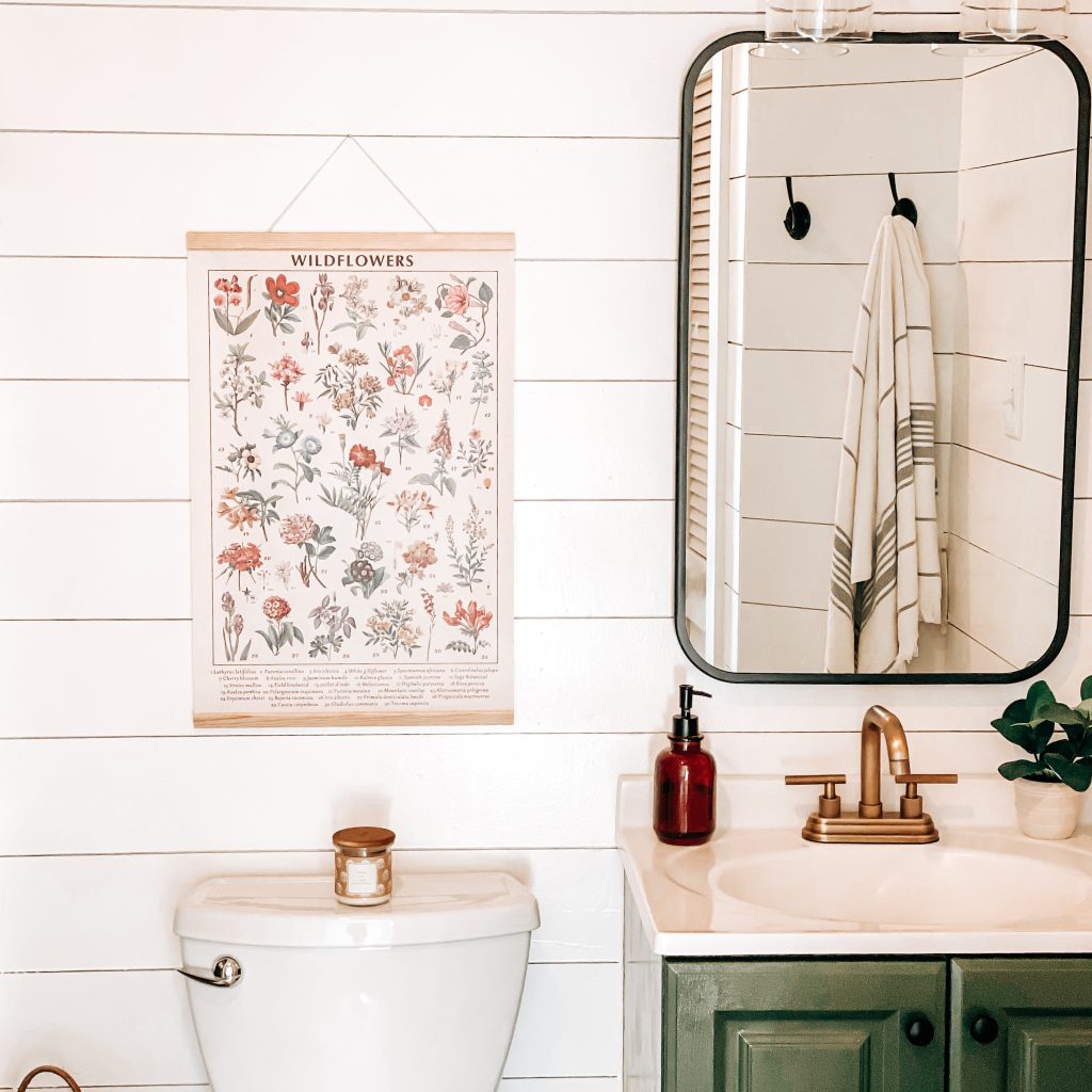 Modern Farmhouse Bathroom on a Budget with front view of our small bathroom renovation project with shiplap walls, modern farmhouse lighting, vintage farmhouse decor, rattan basket, luxury vinyl plank flooring, champagne bronze fixtures and modern farmhouse decor. | The Yellow Rose Farmhouse | www.theyellowrosefarmhouse.com